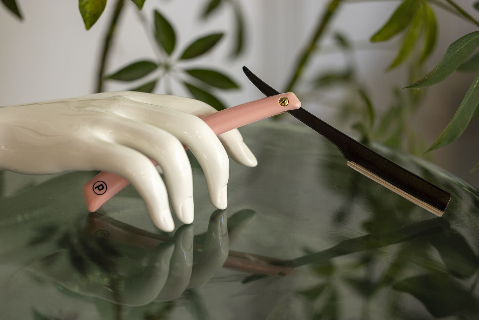 Pink Pony Razor held by a sculpted hand